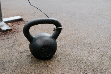 Plakat Kettlebell on rubber surface of outdoor sports ground, copy space. Sport and weightlifting concept