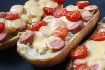 Pizza on bread with cheese and ingredients such as salami, cheese, tomatoes. Selective focus.
