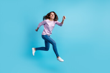 Fototapeta na wymiar Full body profile side photo of young excited woman runner jumper hurry isolated over blue color background
