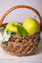 Fototapeta na wymiar Green apple with leaf in a wicker basket