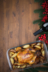 The concept of celebrating Christmas and a gala dinner. Baked chicken and a bottle of wine on a...