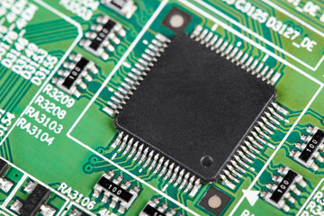 Close-up of a green computer printed circuit board with selective focus on a chip