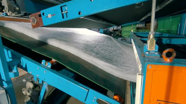 Syntepon manufacturing process. How synthpeon is made. Factory of nonwoven materials. Inside the machine for the production of synthetic winterizer