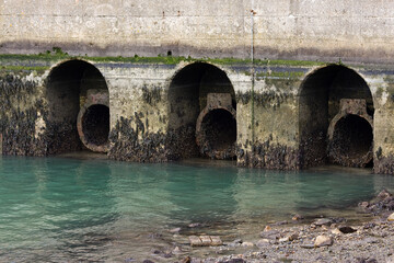 Sewer pipes with waste flowing into a waterway
