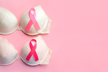 Breast cancer concept. Top view of women's bras and pink ribbon symbol breast cancer awareness