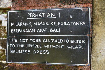 Sign in Indonesian and English Requiring Traditional Dress to Enter Temple in Bali