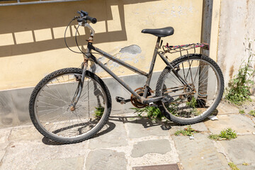Fototapeta na wymiar Old rusty bicycle near the wall