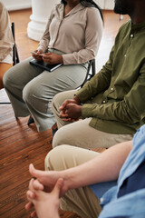 Group of patients attending psychological course sitting in circle at session and listening to...