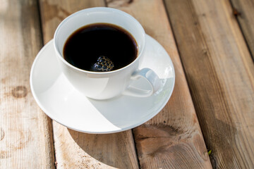 White ceramic coffee cup on the old wooden floor.