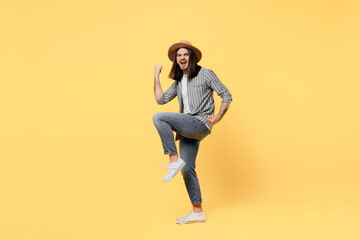 Full body happy young man he 20s wears striped grey shirt white t-shirt hat doing winner gesture celebrate clenching fists say yes isolated on plain yellow background studio. People lifestyle concept.
