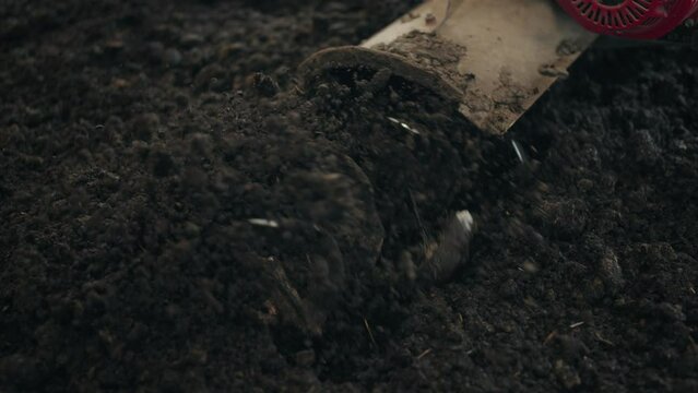 Hand Tractor Tiller Ploughing The Soil In The Field. - close up