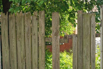 Naklejka premium gray broken wooden plank old wall fence a rural street