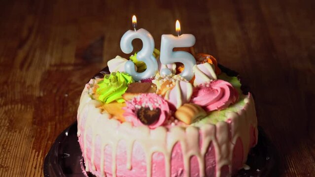 Lighting candles on a birthday cake. 35th birthday. Birth cake with a burning birth candle. Happy Birthday background anniversary celebration concept. High quality 4k footage