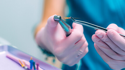 An Endodontist Holding Barbed Broach, Root Canal Treatment in Dental Clinic. - obrazy, fototapety, plakaty