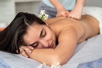Fototapeta na wymiar beautiful woman receive restorative massage on her back in spa salon