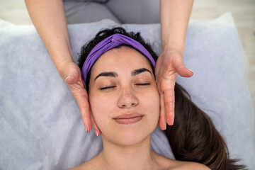 happy beautiful woman with close eye getting relax face massage at spa salon