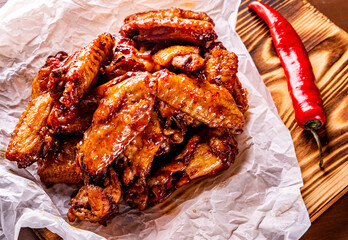 fried chicken wings with sweet chili sauce on white paper