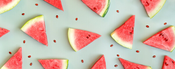 Watermelon banner. Sliced watermelon and seeds on green background. Flat lay, top view.