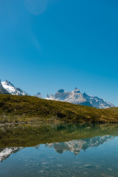 Guernos mountains reflected in Pehoe lake with clear blue sky, Torres del Paine National Park  in Chile