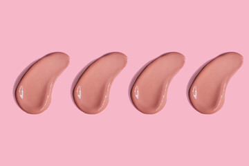 Beige clay mud mask smear smudge swatch isolated on pink background. Cream makeup texture. Bright color cosmetic product stroke swipe sample with pattern flat lay. Beauty routine skin care.