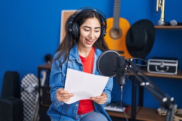 Young hispanic girl artist singing song at music studio