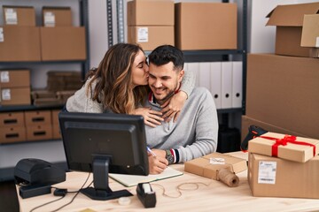 Man and woman ecommerce business workers hugging each other working at office