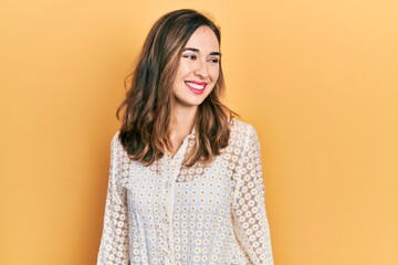 Obraz premium Young hispanic girl wearing casual clothes looking away to side with smile on face, natural expression. laughing confident.