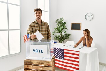 Young american voter man putting vote in ballot box at electoral college.