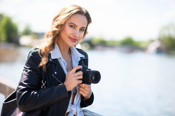 Woman using her digital camera in a park