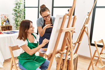 Fototapeta na wymiar Art woman teacher smiling happy looking draw of paint student at studio.