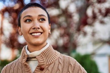 Beautiful hispanic woman with short hair smiling happy outdoors