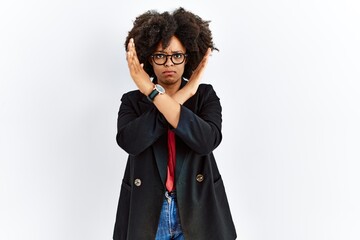 African american woman with afro hair wearing business jacket and glasses rejection expression crossing arms doing negative sign, angry face