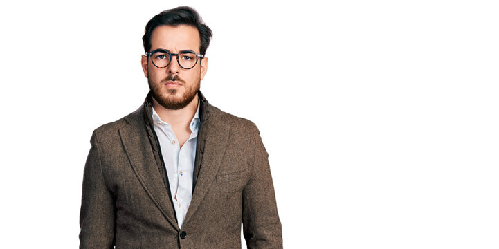 Young hispanic man wearing business jacket and glasses relaxed with serious expression on face. simple and natural looking at the camera.