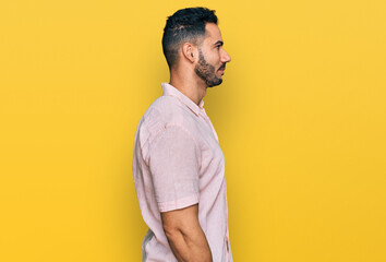 Hispanic man with beard wearing casual shirt looking to side, relax profile pose with natural face...