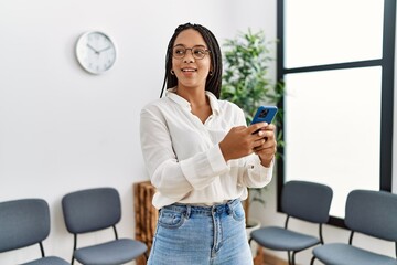 Young african american woman smiling confident using smartphone at waiting room