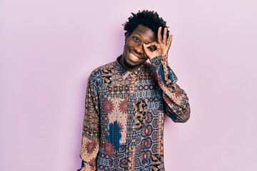 Young african american man wearing casual clothes smiling happy doing ok sign with hand on eye looking through fingers