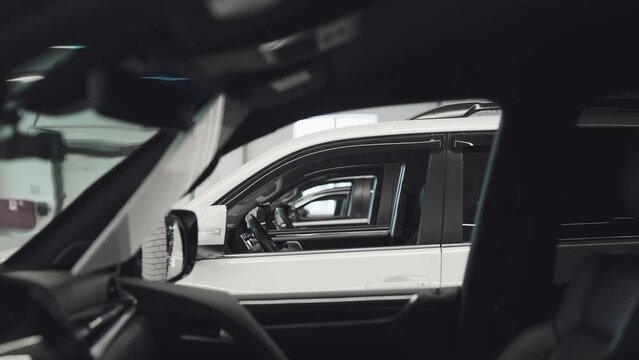 Expensive SUVs are lined up in a showroom. Cars are ready for sale or rent.