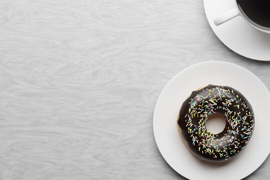 Dougnut and coffee on a plate, white wood background, 3d render. Copy space, food background, delicious donut with chocolate icing