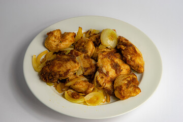 chicken fillet baked in a wok with onions on a plate