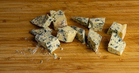 blue cheese cut into cubes on a wooden cutting board