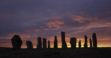 4k cloud and light movement over Callanish Stones at sunrise. Stones in silhouette. No people. Famous prehistoric standing stones, Isle of Lewis, Outer Hebrides, Scotland