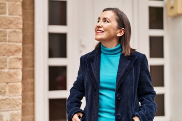 Middle age woman business executive smiling confident standing at street