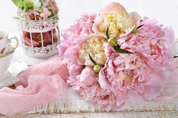 Bunch of pink and yellow peonies lying on the table