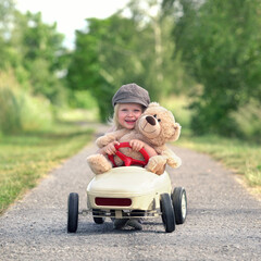 Kind mit teddy im Tretauto