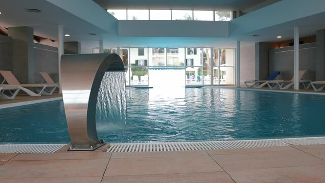 Beautiful indoor pool with Jacuzzi with rattan furniture and large panoramic windows, lighting and finished in loft style
