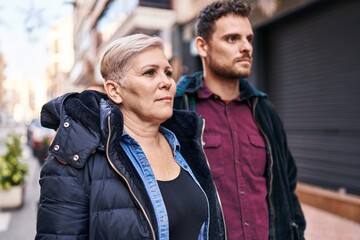 Mother and son with relaxed expression standing together at street