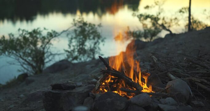 Campfire at a big river in beautiful evening mood