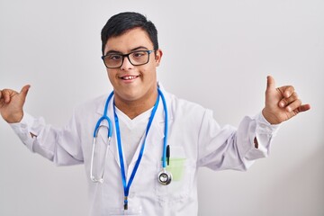 Fototapeta na wymiar Young hispanic man with down syndrome wearing doctor uniform and stethoscope celebrating mad and crazy for success with arms raised and closed eyes screaming excited. winner concept