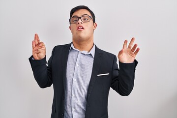 Young hispanic man with down syndrome wearing business style showing and pointing up with fingers...
