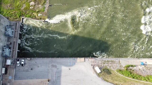 Strong water current generating from Denison dam hydroelectric power plant near parking lots pouring into spillway along Red River between Texas and Oklahoma, USA. Aerial releasing nature resource